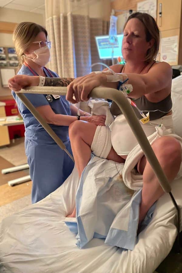 Person in labor rests between contractions using squat bar as a support for angled pushing.