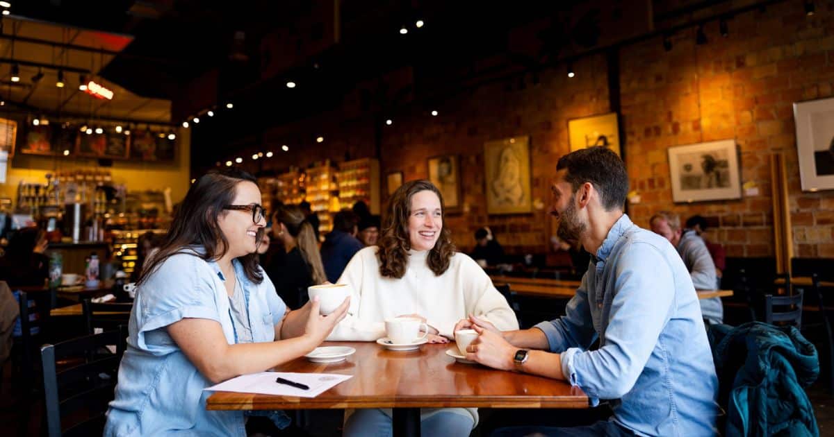 Salt Lake City Beth hardy talking with pregnant couple in a cafe for their doula interview