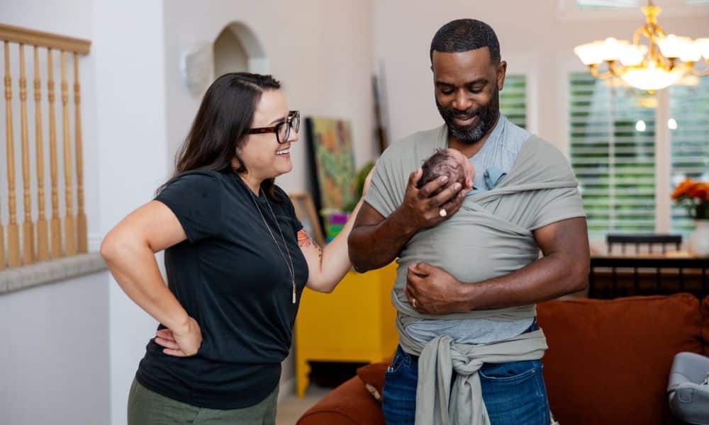Doula Beth Hardy of Heart Tones Birth, winner of the Best Doula Award 2024 in Salt Lake City, supporting new dad with baby in sling