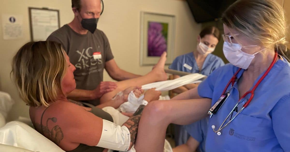Birthing person using Labor Squat Bar in hospital birth with team supporting them