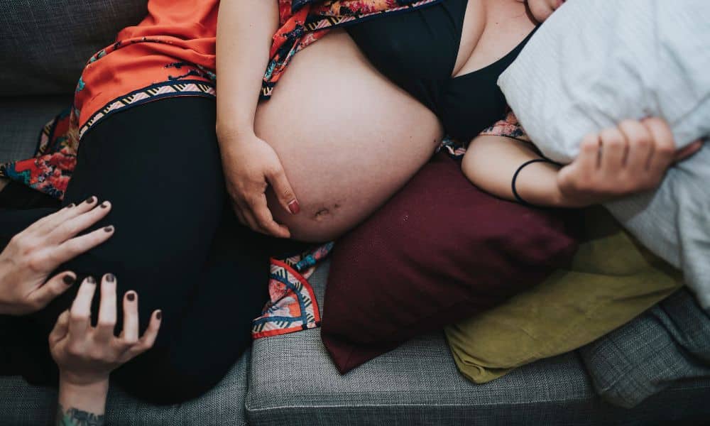 laboring person in side lay position on sofa with support team during contraction