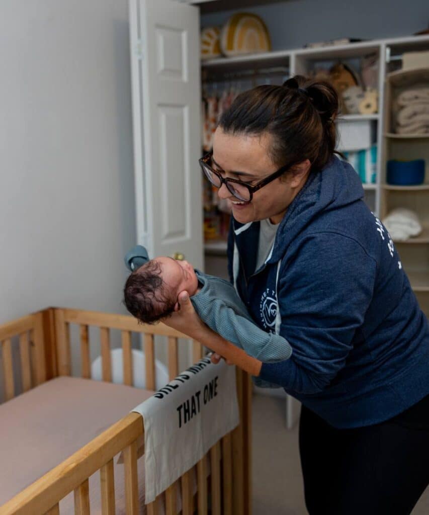 baby sleep coach with infant and crib